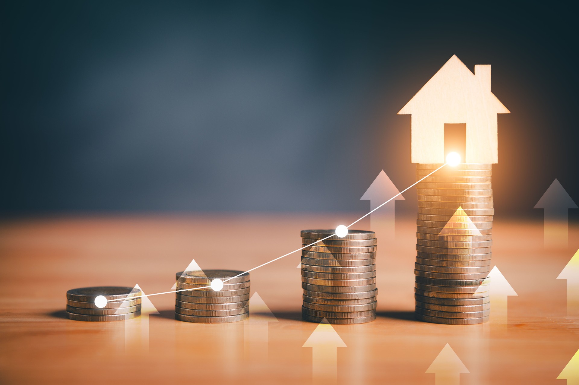Stacks of coins with glowing house icon and upward arrows, symbolizing real estate investment growth.